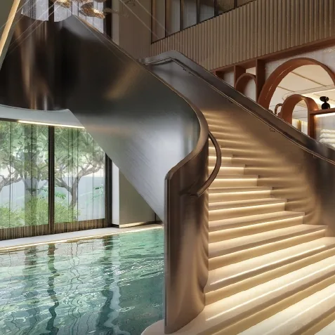 A curved staircase beside an indoor pool in the club café of Godrej Epoque